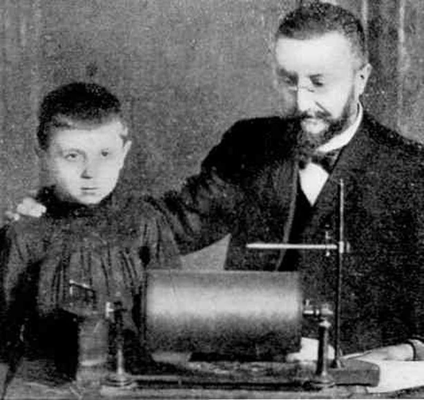 Alfred Binet examining a child seated next to a kymograph and other psychophysical measurement instruments.